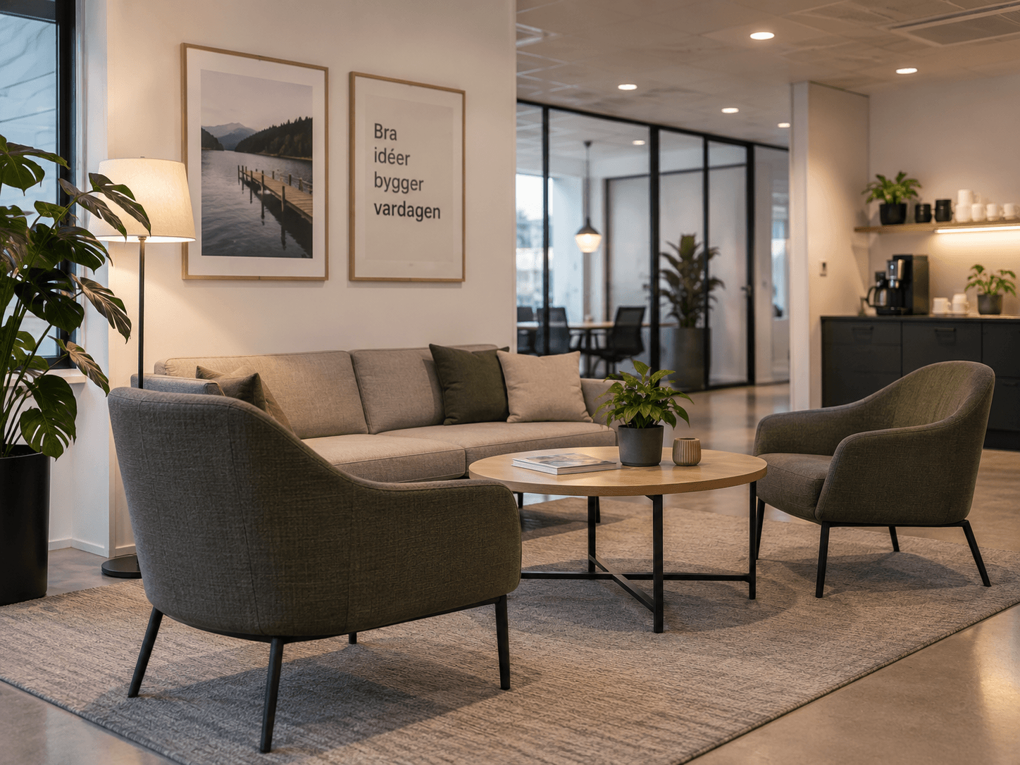 Lounge på ett kontor med soffa och två fåtöljer i grått och grönt tyg